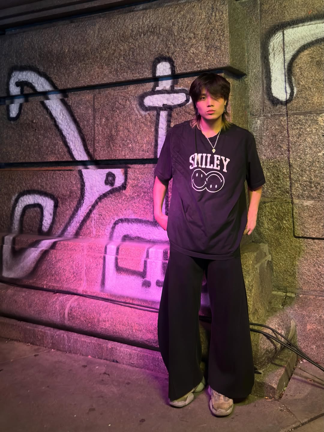 Jeffrey Zhao standing by a mural at night